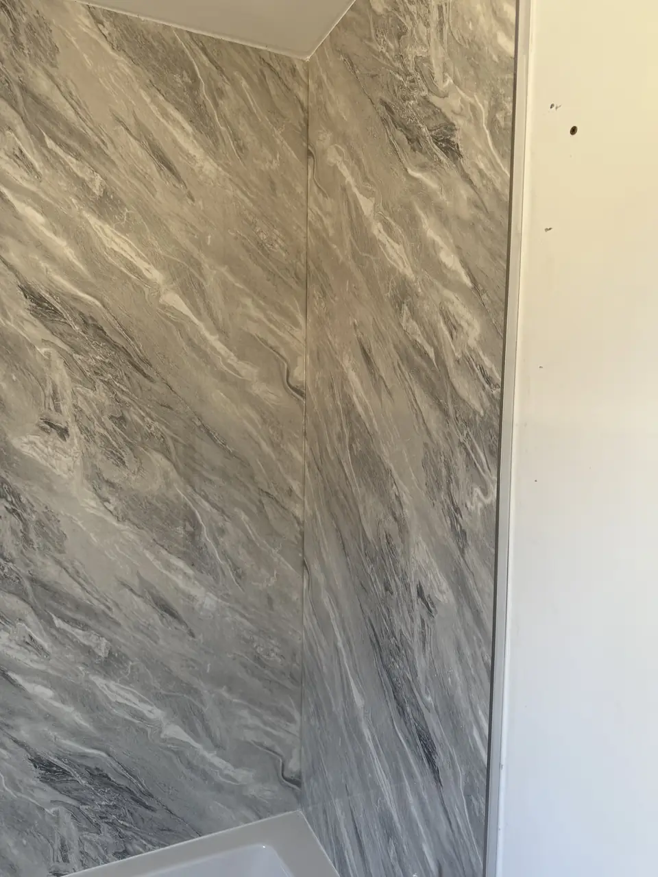 Seamless marble-effect wall panels in a shower area