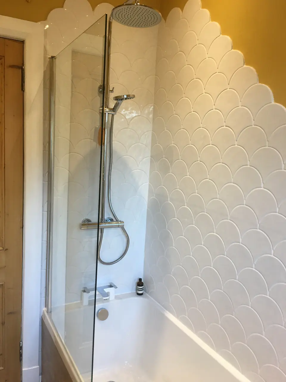 Shower over bath with glass screen and rainfall shower head