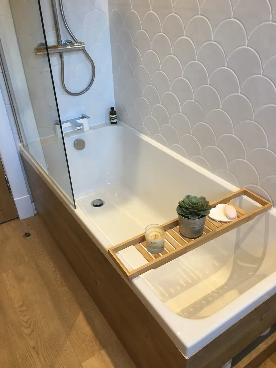 Bath with chrome thermostatic shower and wooden bath caddy