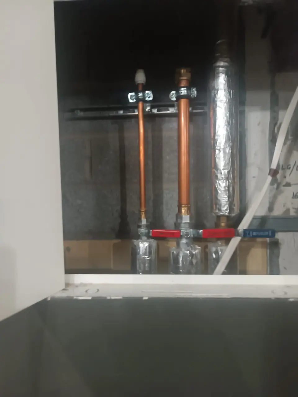 New copper supply pipes with red isolation valves, fitted to replace old pipework