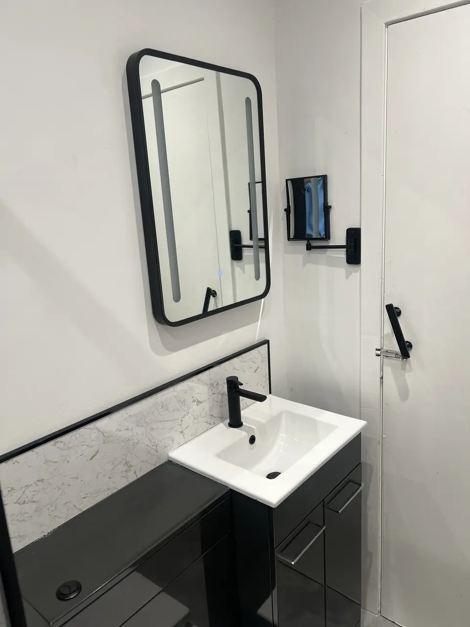 Compact vanity with black tap and LED mirror