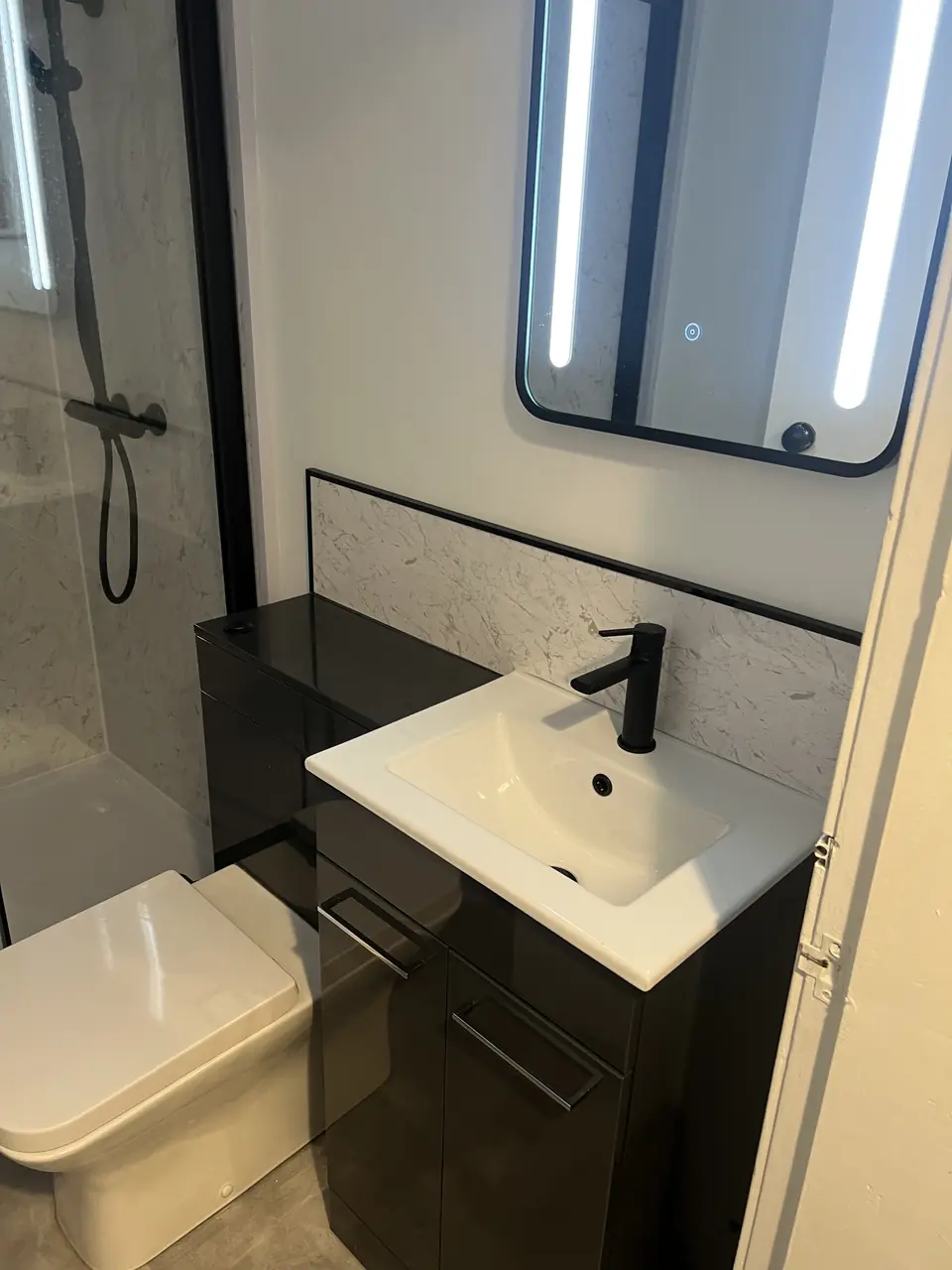 Gloss black vanity unit, back-to-wall toilet and shower enclosure